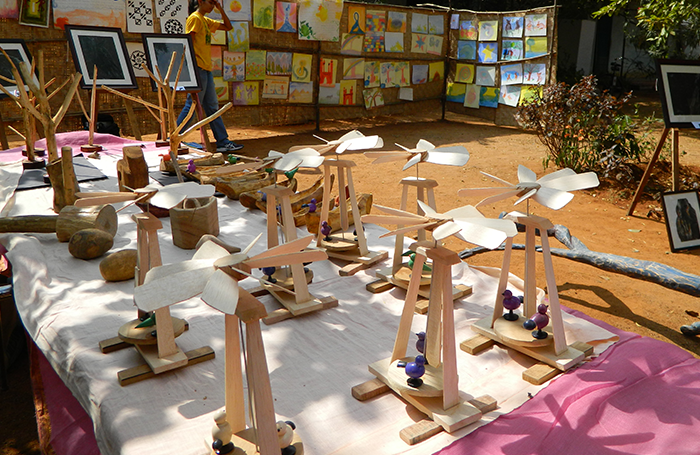A student walks through an open-air space filled with art exhibits and stalls.